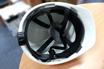A white safety helmet to protect workers' heads from work accidents, such as collisions with hard...