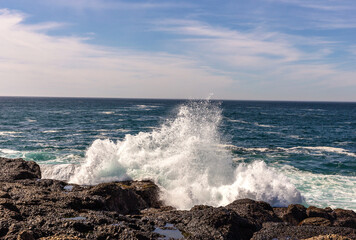A view on Pacific ocean coast with blue sky and water and waves