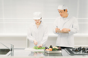 食品工場で働く男女の調理員（分析・検査）
