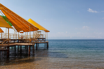 large pier with a roof and a rusty staircase descending into the water