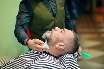 Obraz na płótnie Canvas Crop barber sweeping neck of client