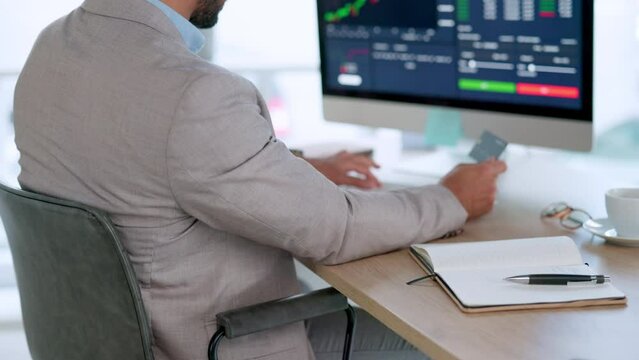 A professional investment banker buying and selling stock on his computer in a modern office. Closeup of a finance manager adding his card information online. Financial analyst reading trading data