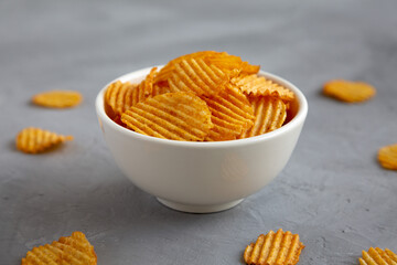 Crispy Barbeque Potato Chips in a Bowl on a gray background, side view. Close-up.