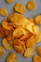 Crispy Barbeque Potato Chips on a gray surface, top view. Flat lay, overhead, from above.