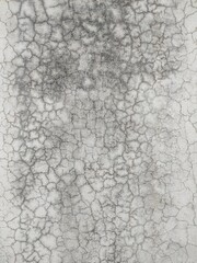 Abstract paint is peeling off the building wall.Close-up. Badly fixed building facade wall covered with cracks in stucco and paint. Missing patch of paint in the middle; crack with flappy.
