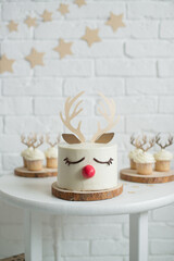 Christmas cake with deer antlers and a big red nose on a white background