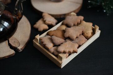 Ginger cookies in the shape of a Christmas tree on a black table