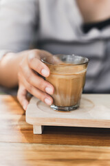 Woman is holding a glass of espresso shot over cold fresh milk. Dirty Coffee, Coffee menu, Milk Coffee