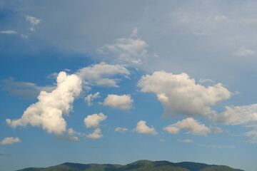 The white clouds have a strange shape and moutain.The sky and the open space have mountains below.