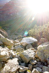 A beautiful ray of sun breaks through the mountains, showing the beauty of the mountain stones at sunset