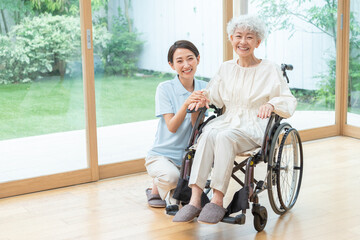 Obraz na płótnie Canvas 車椅子に乗ったシニア女性と介護士（介護・福祉・ヘルパー）