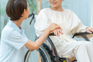 車椅子に乗ったシニア女性と介護士（介護・福祉・ヘルパー）