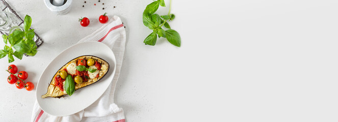 Grilled eggplants banner. Aubergine baked with mozzarella, tomatoes, basil and olives on a plate on white background. web line. Italian Restaurant banner. top view, copy space