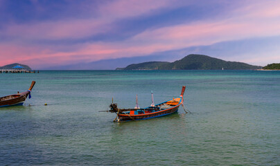 Colourful Skies Sunset over Rawai Beach in Phuket island Thailand. Lovely turquoise blue waters, lush green mountains colourful skies and beautiful views of Pa Tong Patong
