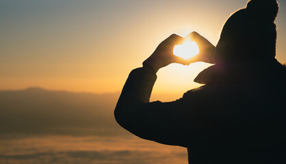 Woman making heart shape during sun rise, God is love concept, Heart shape, Mountain tourism,...