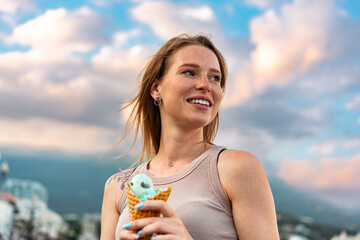 Young woman with ice cream walking in the street