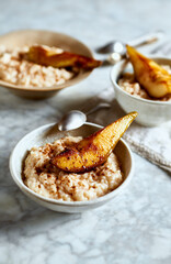 Rice pudding with baked pears and cinnamon. Homemade autumnal dessert