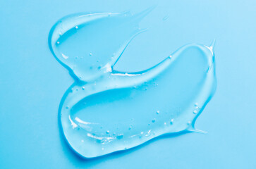 A drop of liquid gel or cosmetic serum or cleansing lotion against acne. Blue background.