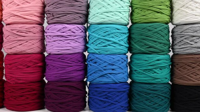 Close-up of rows of multicolored cotton skeins and a mug of black coffee