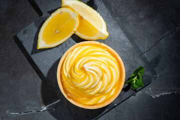 Detailed close up of a delicious lemon custard tart with fresh mint.