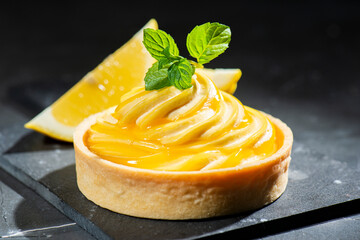 Detailed close up of a delicious lemon custard tart with fresh mint.
