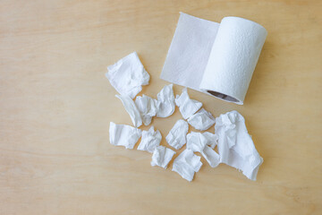 Trash of used tissue paper with toilet paper roll with space on wood background, white tissue paper waste