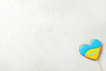 Obraz premium Cookie with Ukrainian flag colors and text HOME on light textured background