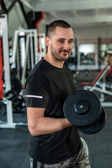 Fototapeta na wymiar young sporty man doing exercising with dumbbell in gym