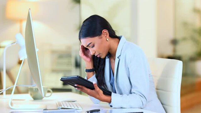 Stressed designer feeling annoyed frustrated and suffering from a headache or migraine while trying to meet a deadline. Tired creative making a mistake and feeling anxious while working on a tablet