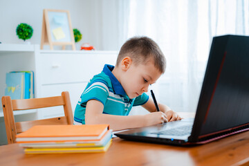 Fototapeta na wymiar Distance learning online education. A schoolboy boy studies at home and does school homework. A home distance learning