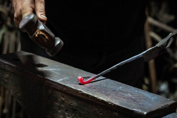 Close up view of heated metal and anvil. Blacksmith in the production process of other metal...