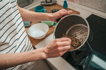 Female cook cooking the oatmeal for breakfast