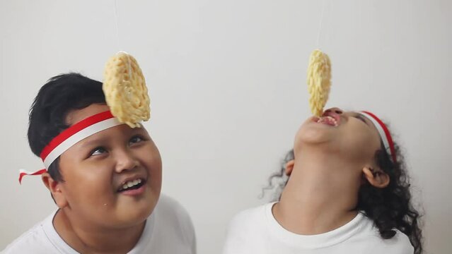 Asian kids celebrating indonesian independence day with cracker eating contest. The welcoming independence day