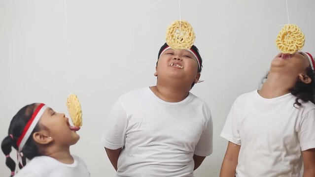 Asian kids celebrating indonesian independence day with cracker eating contest. The excitement of children in welcoming independence day