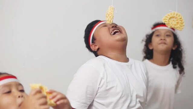ExcitedAsian kids celebrating indonesian independence day with cracker eating contest. The excitement of children in welcoming independence day