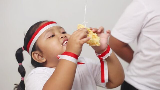 Funny Asian kids celebrating indonesian independence day with cracker eating contest. The excitement of children in welcoming independence day