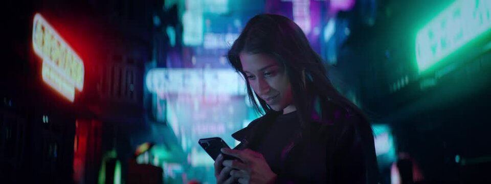 CU Night portrait of Hispanic female using her mobile phone in the street filled with neon signs. Hong Kong style background
