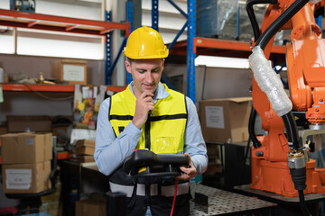Engineer wearing helmet and hi visible vest working in factory welding robotic automation happy smiling with quality control pass 
