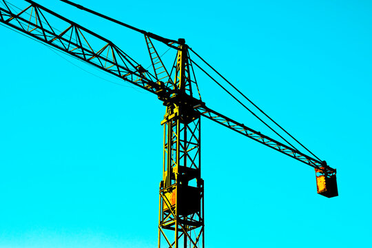 Artistic interpretation of an old tower crane in a blue background - concept image