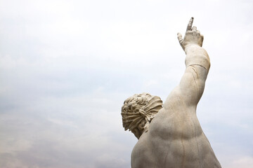 Statue of a man pointing to the sky on white background - concept image