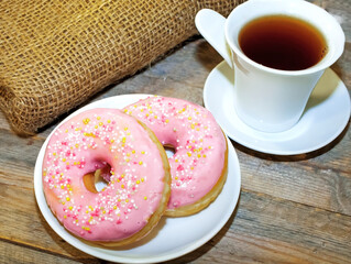 Sweet tasty donuts with sprinkling and fragrant tea.