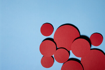 Different red textured circles soar as swarm shape on blue background, decorative border with copy space for text, colorful abstract backdrop in simple minimal style.