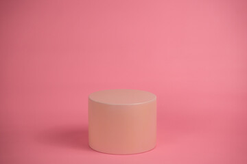 Empty podium for display cosmetic product. Platform arrangement in pink pastel color in trendy minimalist style. Composition of cylinders and cubes layout for feminine background