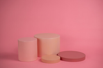 Empty podium for display cosmetic product. Platform arrangement in pink pastel color in trendy minimalist style. Composition of cylinders and cubes layout for feminine background