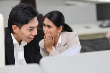 Business people gossiper group whispering or sharing rumor about their colleague in the office. Female coworker sitting and telling gossip to male workmate about bullying problem at work place