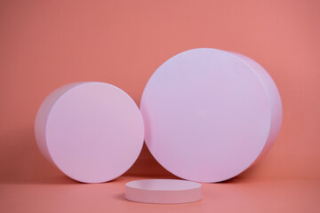 Empty podium for display cosmetic product. Platform arrangement in pink pastel color in trendy minimalist style. Composition of cylinders and cubes layout for feminine background