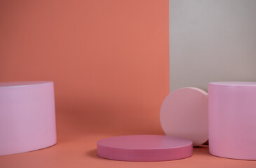 Empty podium for display cosmetic product. Platform arrangement in pink pastel color in trendy minimalist style. Composition of cylinders and cubes layout for feminine background