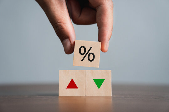 businessman holding a wooden block with percentage and up or down arrow Mortgage and Loan Rates Interest rates, stocks, ratings, interest rate ideas are falling or vice versa. business idea