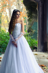 Beautiful bride standing in the old ruined building on autumn day