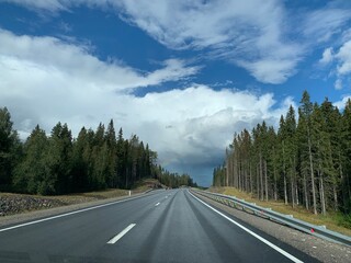 Road among the hills and woodlands under an overcast sky